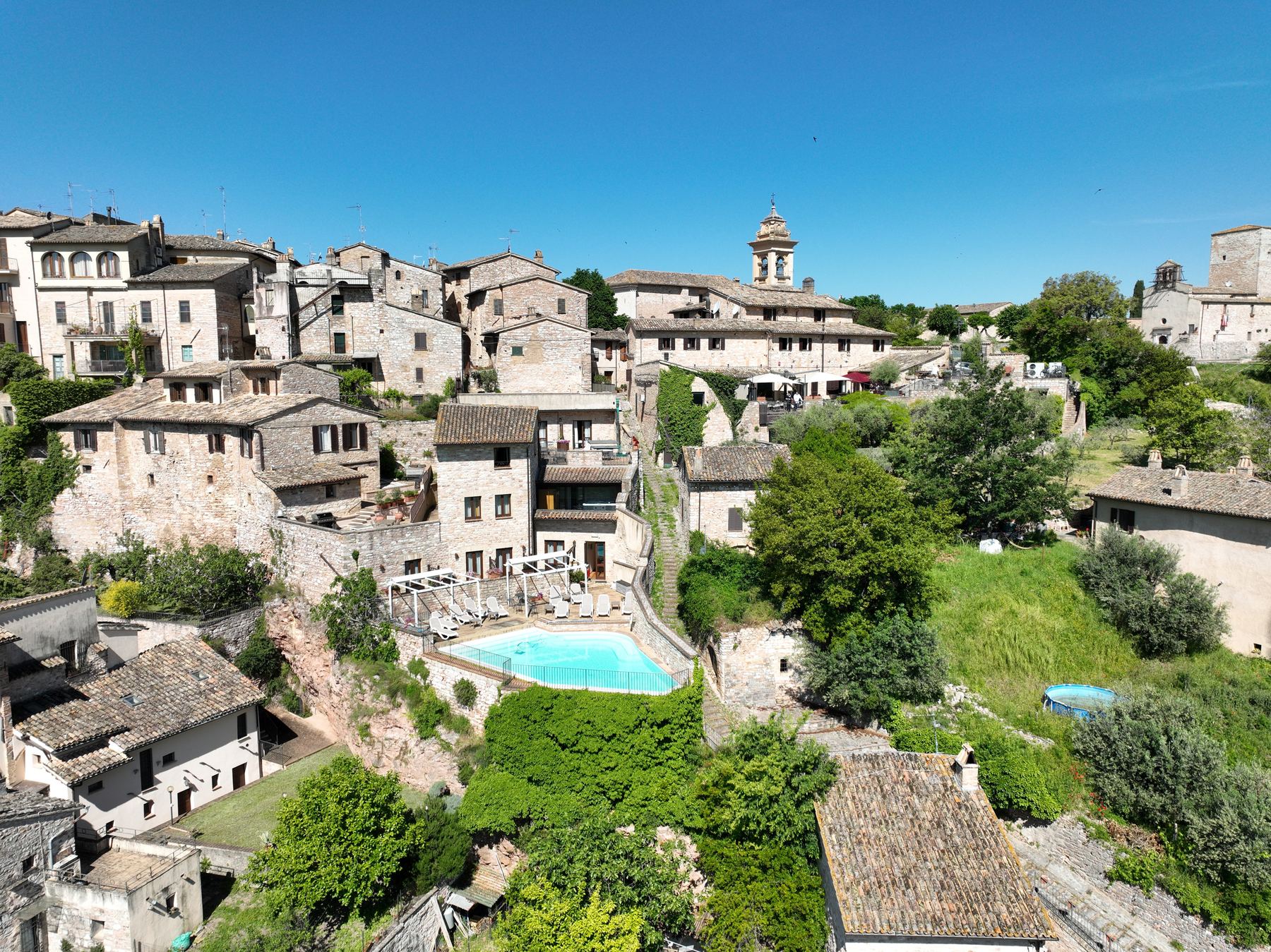 Spello vista dall’alto: le case in pietra del borgo e la piscina de La Bastiglia